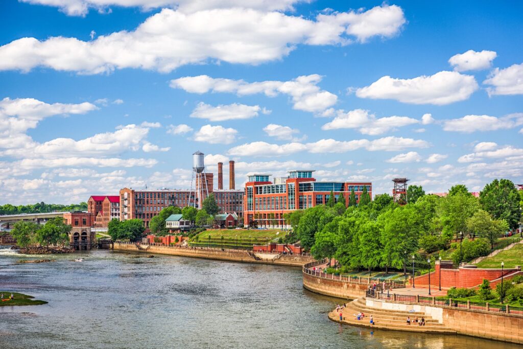 A lush riverfront skyline on a bright summer day captures the energy and outdoor appeal that make Columbus, GA an ideal home for retirement communities and summer activities for seniors.